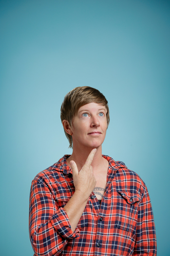 Marina DeVol smiling and looking up, wearing a red plaid shirt